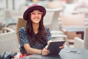 ポケットwifiの新機種とタブレットを使って、カフェでネットを楽しむ美女